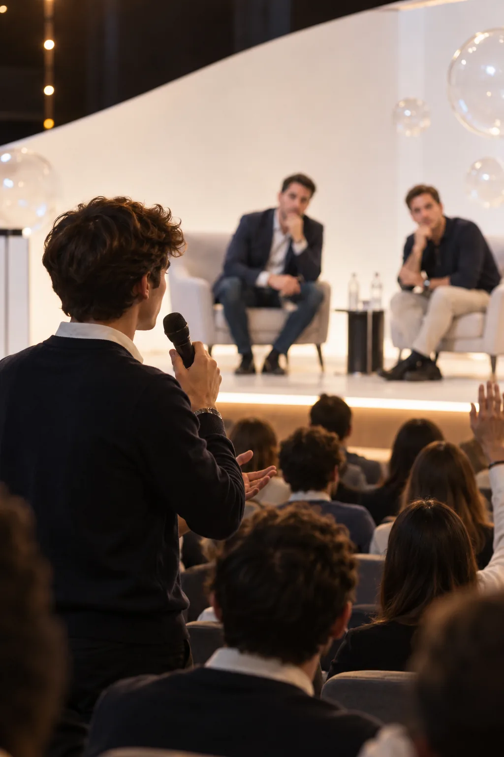 Una persona del pubblico fa una domanda agli speaker